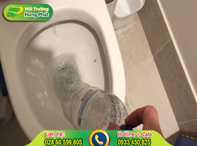 Nh&eacute;t đầu chai v&agrave;o r&atilde;nh tho&aacute;t nước dưới đ&aacute;y bồn cầu